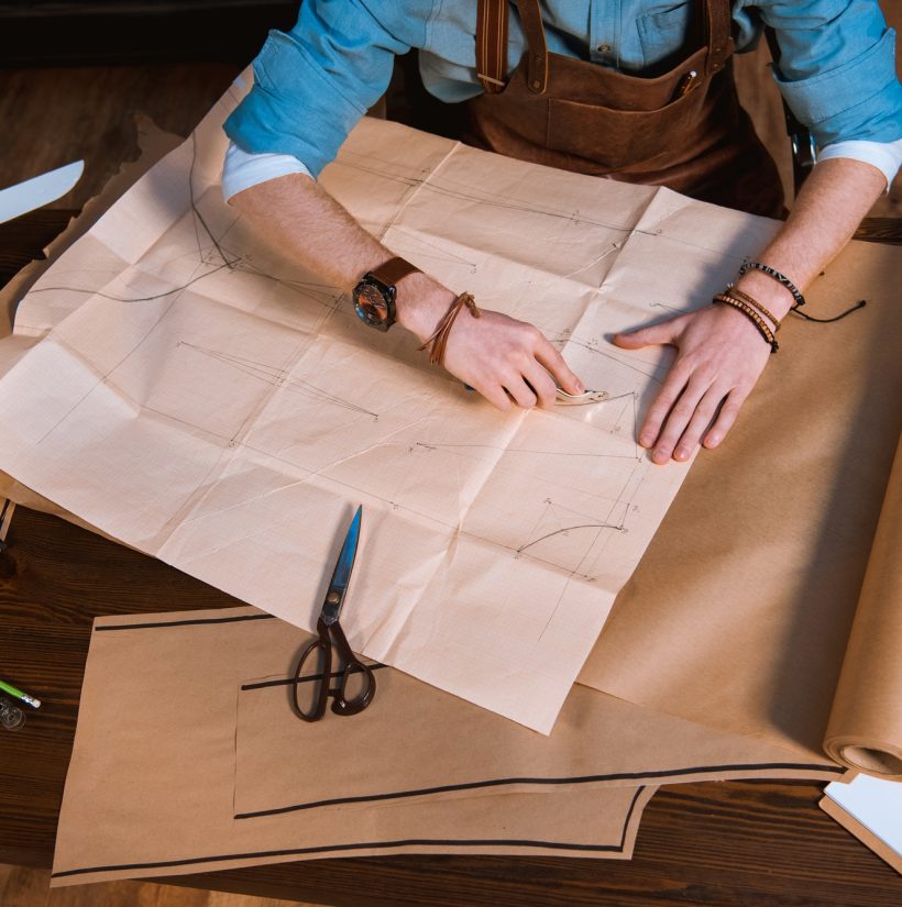 cropped-shot-of-male-fashion-designer-in-apron-making-sewing-patterns-at-workplace.jpg